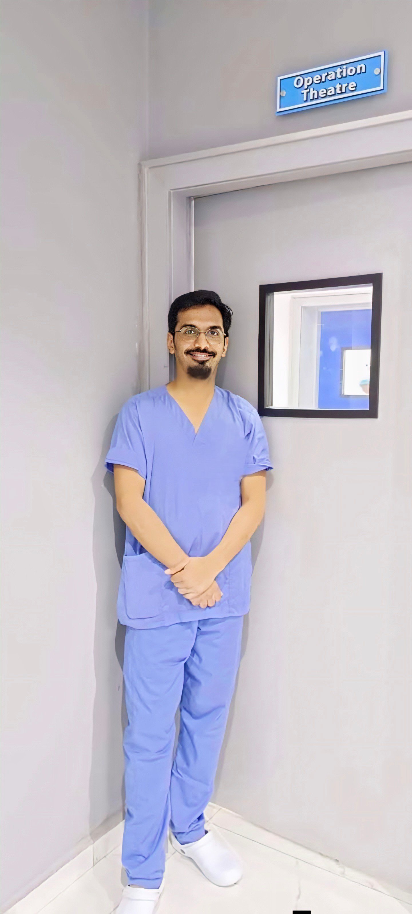 Dr. Harshit Vaidya in surgical scrubs outside the operation theatre